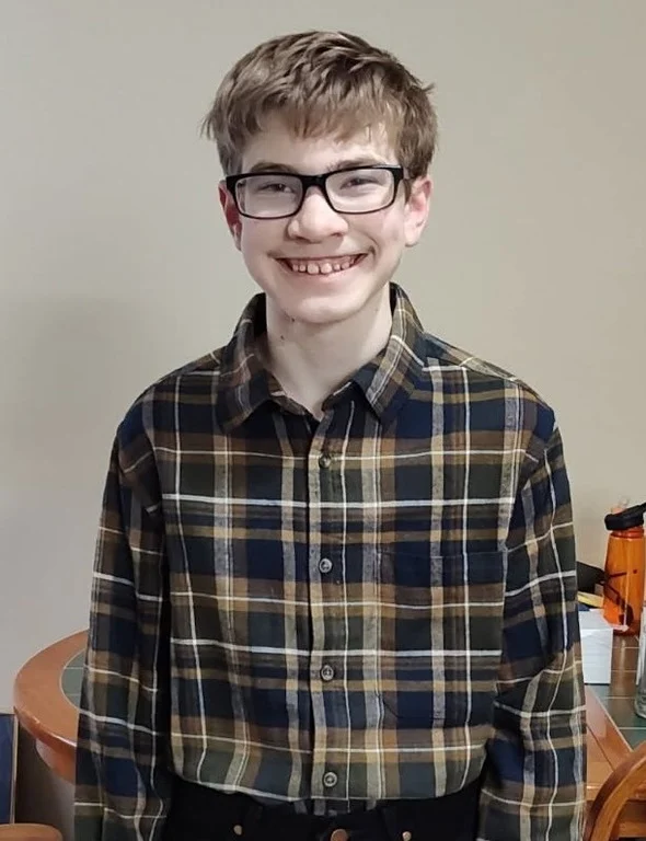 Sebastian Wayne Drake Rogers smiling in a portrait photo wearing glasses.